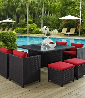 7 piece dark brown wicker outdoor dining set with red cushions, ottoman, and table without glass top.”