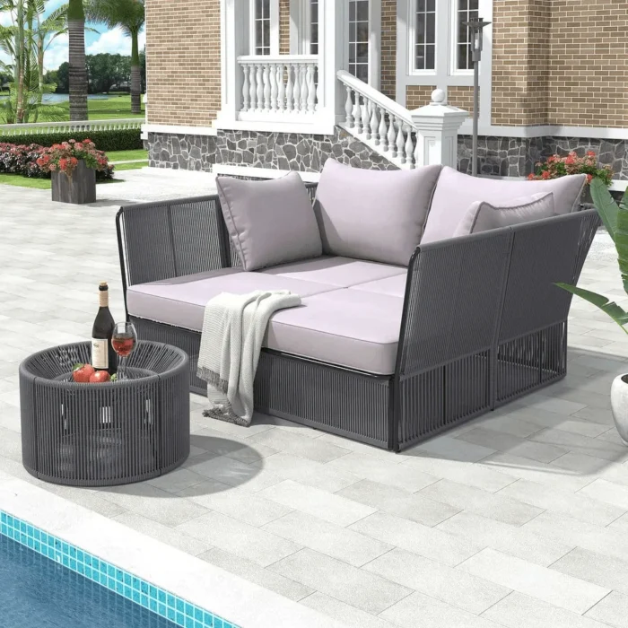 Outdoor grey chaise lounge set with daybed and clear tempered glass side table on a patio.