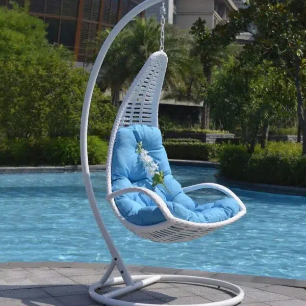 White single-seater hanging swing with a sturdy stand, placed in a garden setting.