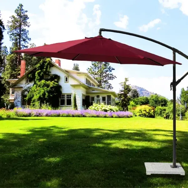 9-foot red offset cantilever patio umbrella with marble base and crank handle in a backyard setting