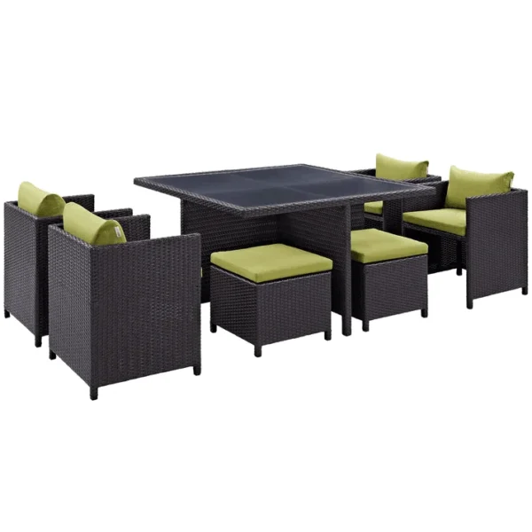7-piece dark brown wicker outdoor dining set with green cushions, including ottoman and table without glass top