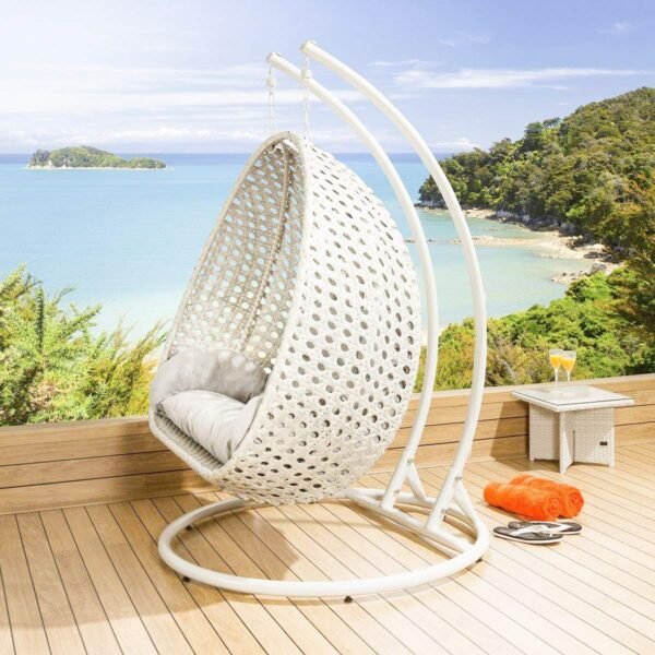 Double seater hanging swing chair in white with soft cushions, placed in a modern outdoor setting.