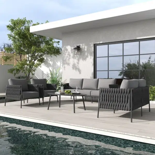 Grey 7-seater rope sofa set with washable soft cushions and glass top table in an outdoor backyard setting.