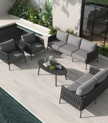 Grey 7-seater rope sofa set with washable soft cushions and glass top table in an outdoor backyard setting.