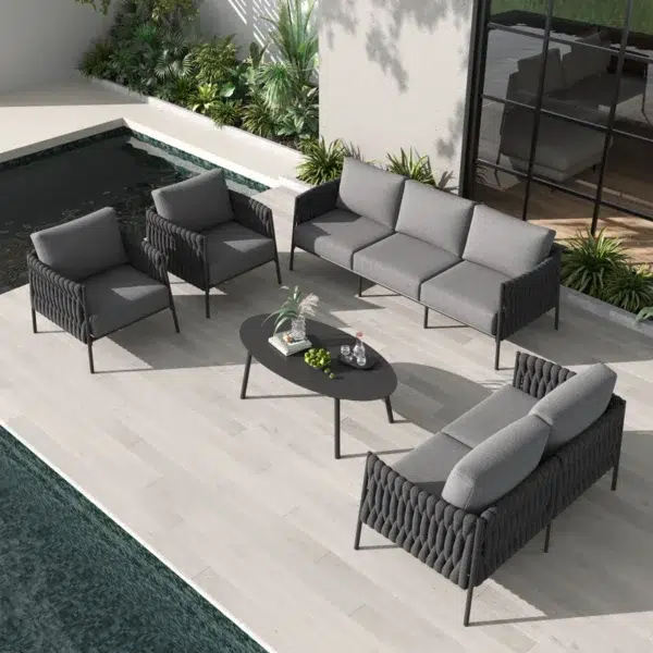 Grey 7-seater rope sofa set with washable soft cushions and glass top table in an outdoor backyard setting.