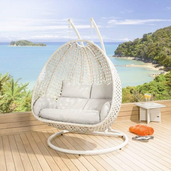 Double seater hanging swing chair in white with soft cushions, placed in a modern outdoor setting.