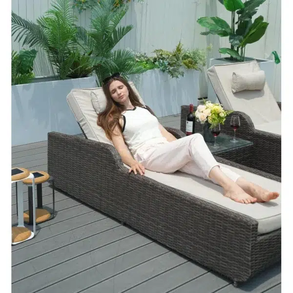 Rattan wicker long reclining outdoor chaise lounge in brown and off-white with cushions.