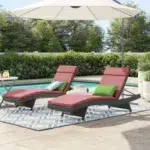 Set of 2 outdoor patio recliner lounger chairs in dark brown with red all-weather cushions.