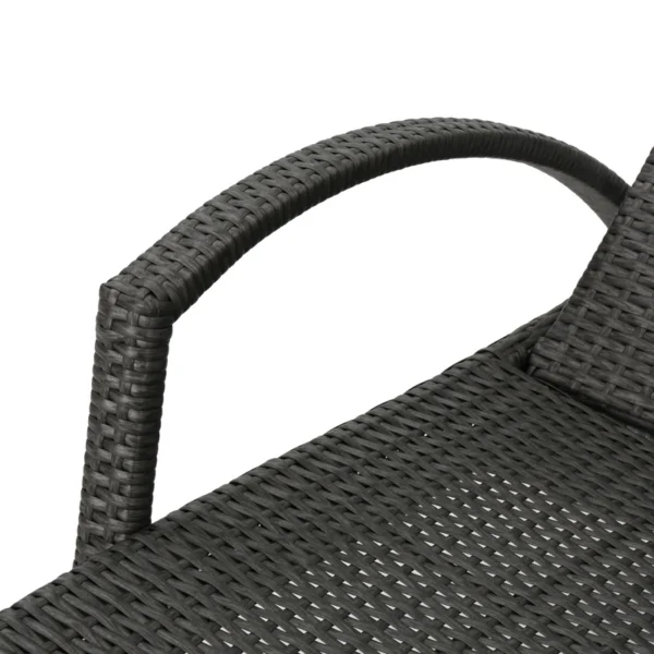 Black outdoor chaise lounge set with matching side table on a patio with greenery in the background.