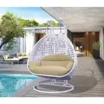 Double seater hanging swing chair in white and cream, suspended from a sturdy frame, perfect for indoor or outdoor relaxation.