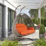 Double seater swing with unique design in dark brown frame and orange cushions, perfect for indoor or outdoor use