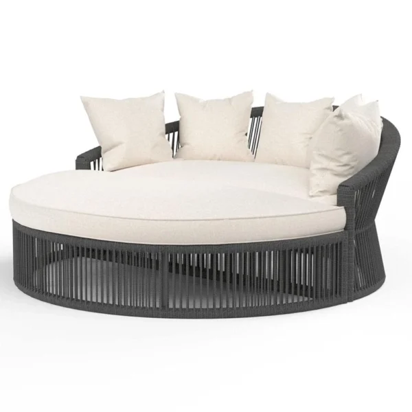Round black daybed with cushions and low-profile table, styled for outdoor relaxation