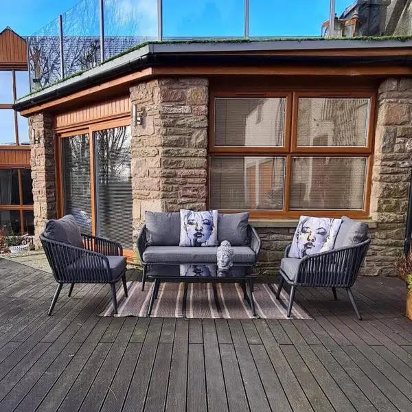 Grey 4 seater rope sofa set with cushions placed in a modern outdoor setting