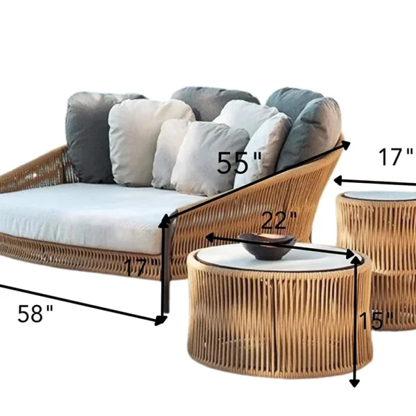 Beige and off-white outdoor rope daybed with plush cushions on a wooden deck surrounded by greenery.