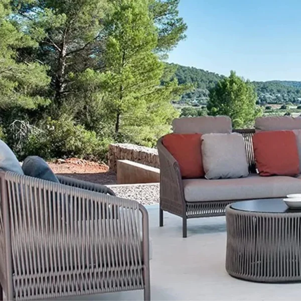 Outdoor 5-seater grey rope patio sofa set with center and side tables on a garden terrace, perfect for backyard and poolside lounging.