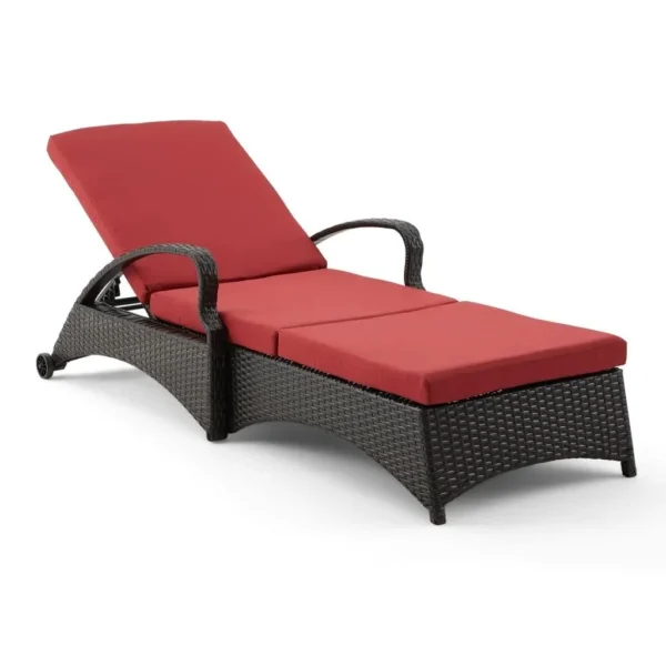 Red wicker rattan outdoor patio chaise lounge chair with side table, perfect for relaxing outdoors.