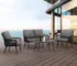 4-seater outdoor/indoor black and grey sofa set with center table and cushioned chairs, placed on a patio.