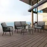 4-seater outdoor/indoor black and grey sofa set with center table and cushioned chairs, placed on a patio.