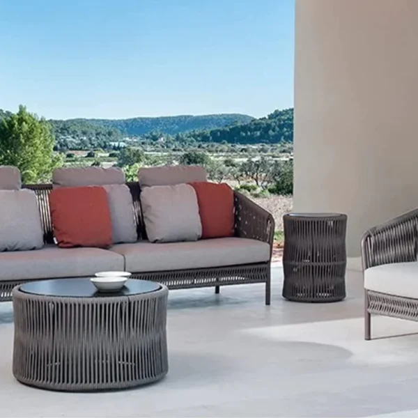 Outdoor 5-seater grey rope patio sofa set with center and side tables on a garden terrace, perfect for backyard and poolside lounging.