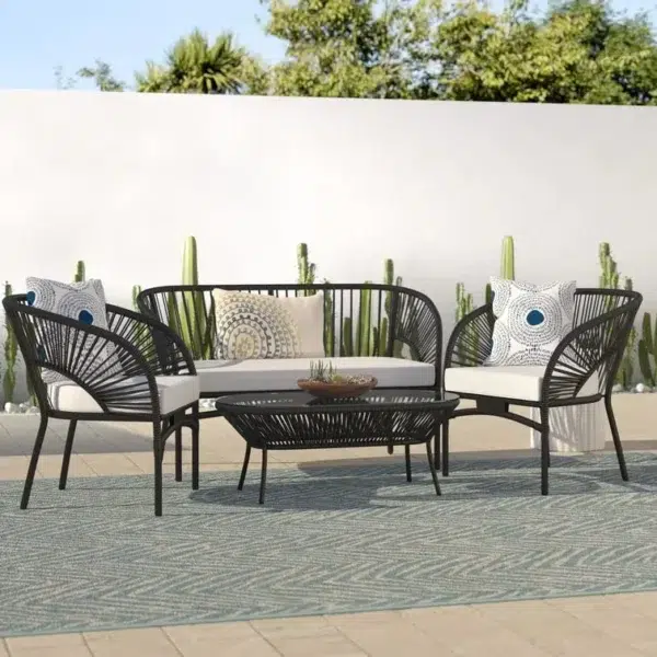 4-seater outdoor rope sofa set in black and white with a matching center table placed on a patio.