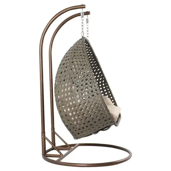 Double seater hanging swing chair with dark brown wicker frame and cream cushions