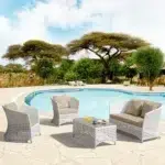 Outdoor 4-seater sofa set with white and beige cushions, placed in a garden setting for relaxation.