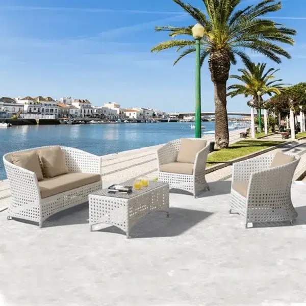 Outdoor 4-seater sofa set with white and beige cushions, placed in a garden setting for relaxation.