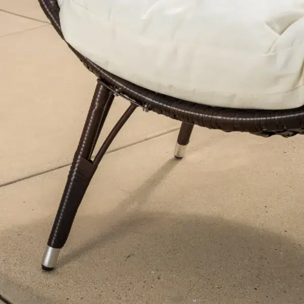 Brown single seater swing basket hanging in balcony with cushions.