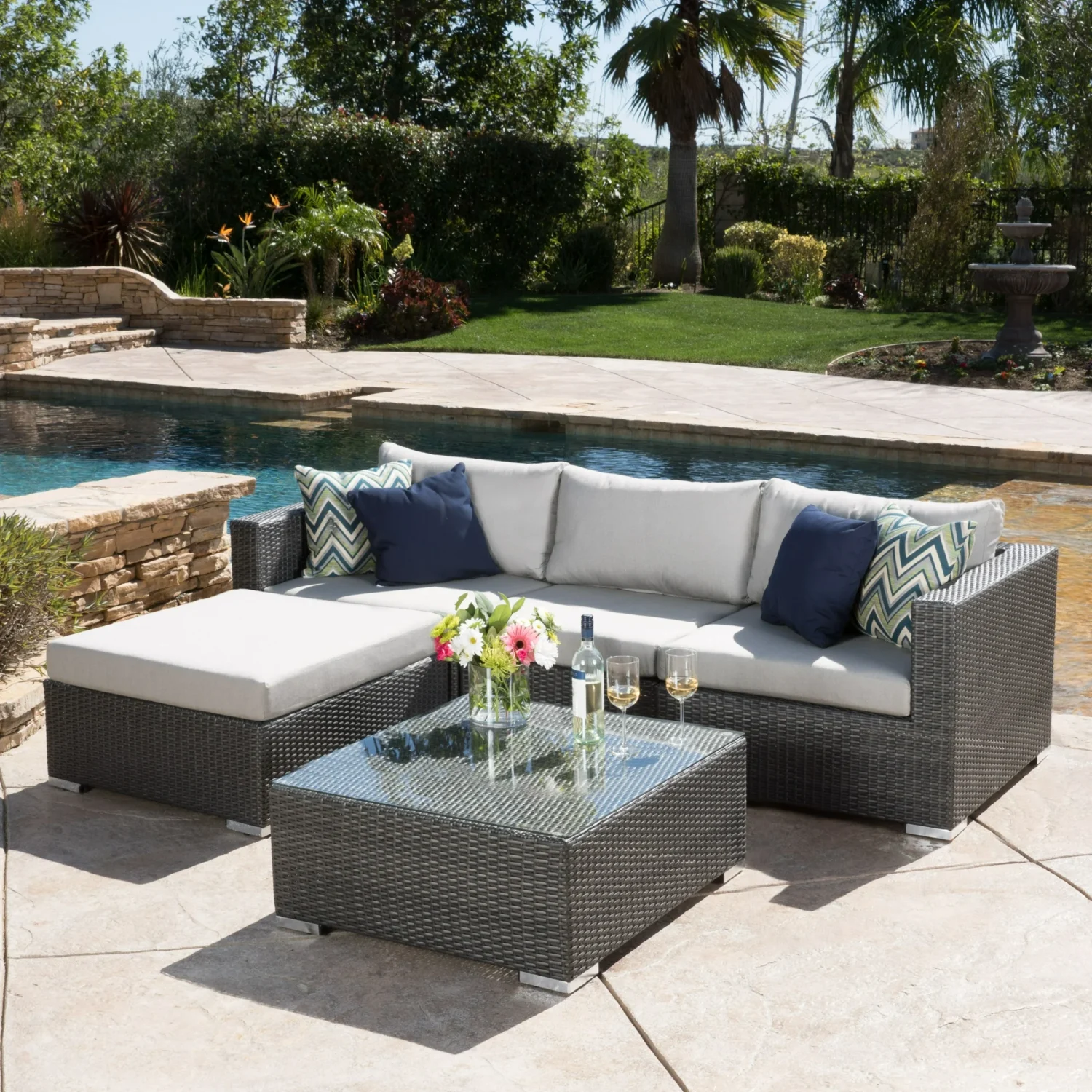 4 seater outdoor wicker sectional sofa set in brown frame with light grey cushions placed on a patio.