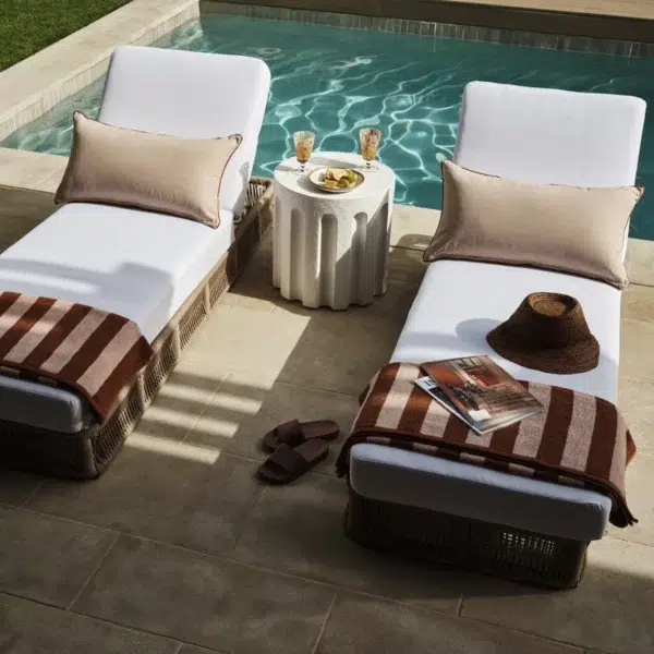 Two beige rope sun loungers with plush white cushions, perfect for outdoor relaxation.