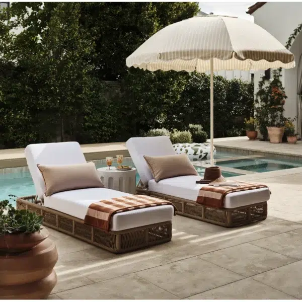 Beige rope sun lounger with a plush white cushion placed outdoors for comfortable lounging.