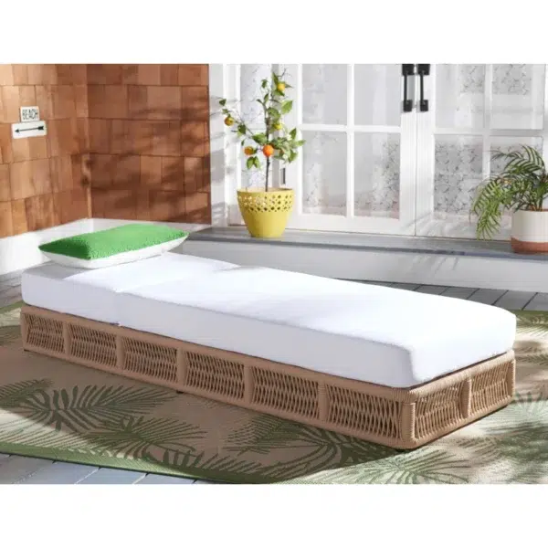 Beige rope sun lounger with a plush white cushion placed outdoors for comfortable lounging.