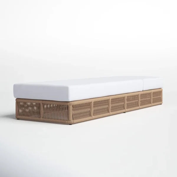 Beige rope sun lounger with a plush white cushion placed outdoors for comfortable lounging.
