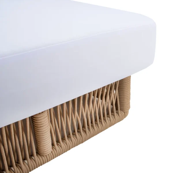 Beige rope sun lounger with a plush white cushion placed outdoors for comfortable lounging.