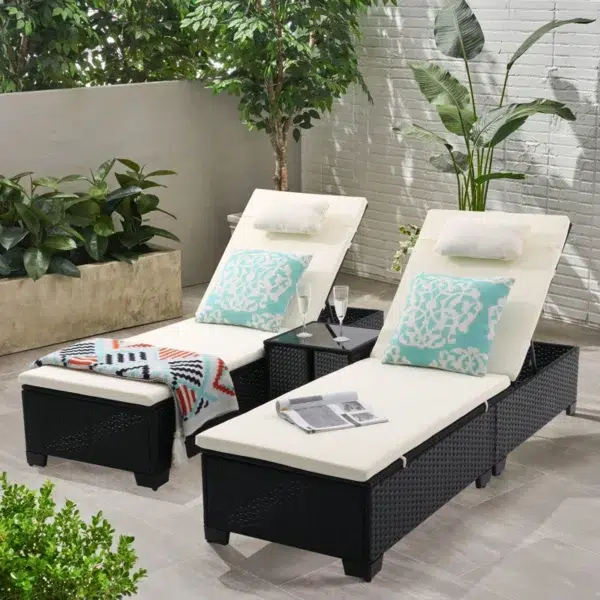 Set of 2 off-white wicker rattan outdoor chaise lounge chairs with matching side table on a patio.
