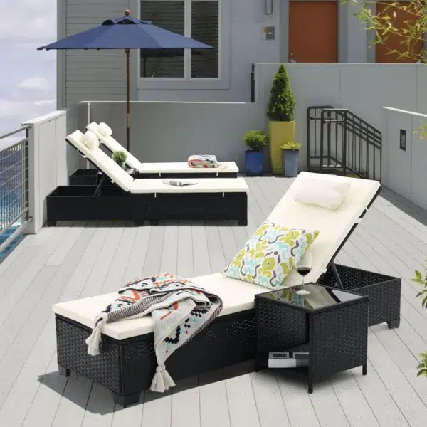 Set of 2 off-white wicker rattan outdoor chaise lounge chairs with matching side table on a patio.