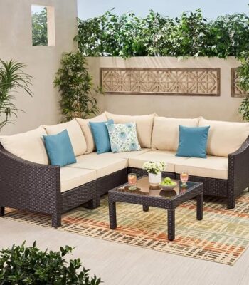 "4-piece outdoor patio furniture set with rattan sofa, cushioned chairs, and coffee table in a garden setting"