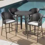 “5-piece outdoor patio bar set with rattan wicker finish, including bar table and matching stools, placed on a deck with outdoor greenery.”