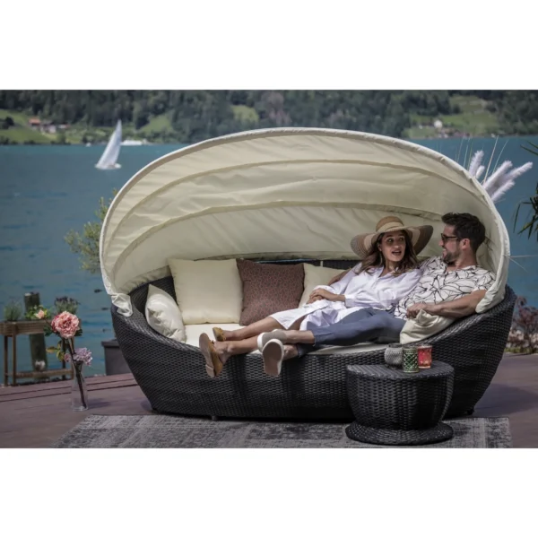 Luxury outdoor wicker patio daybed with retractable canopy for all-weather comfort.