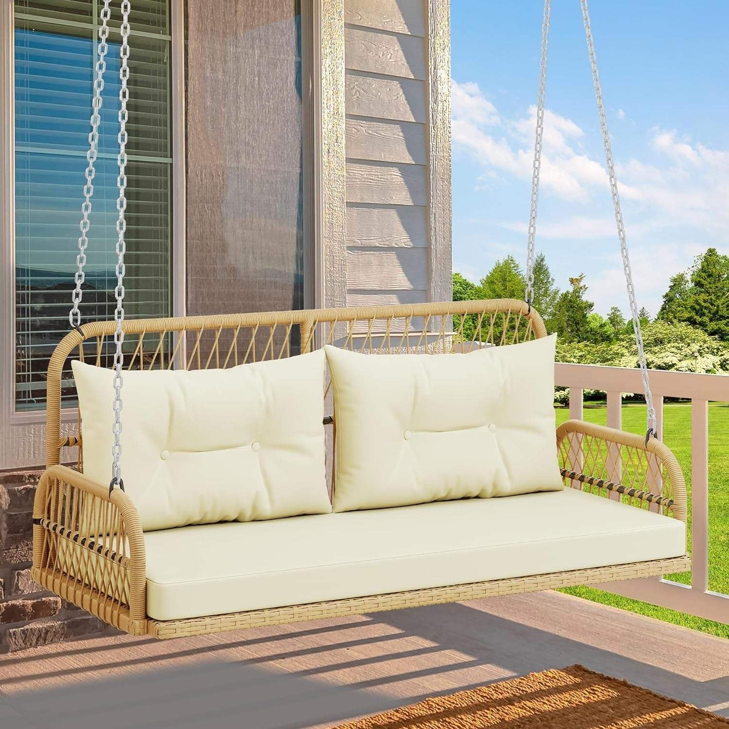 Outdoor beige rattan wicker two-seater sofa swing with cushions for patio or garden