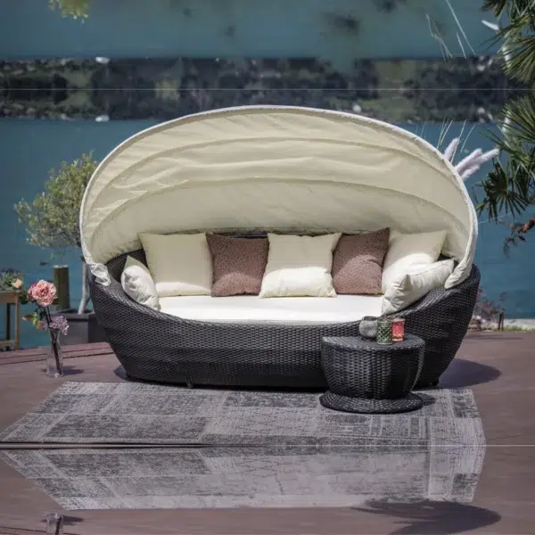 Luxury outdoor wicker patio daybed with retractable canopy for all-weather comfort.