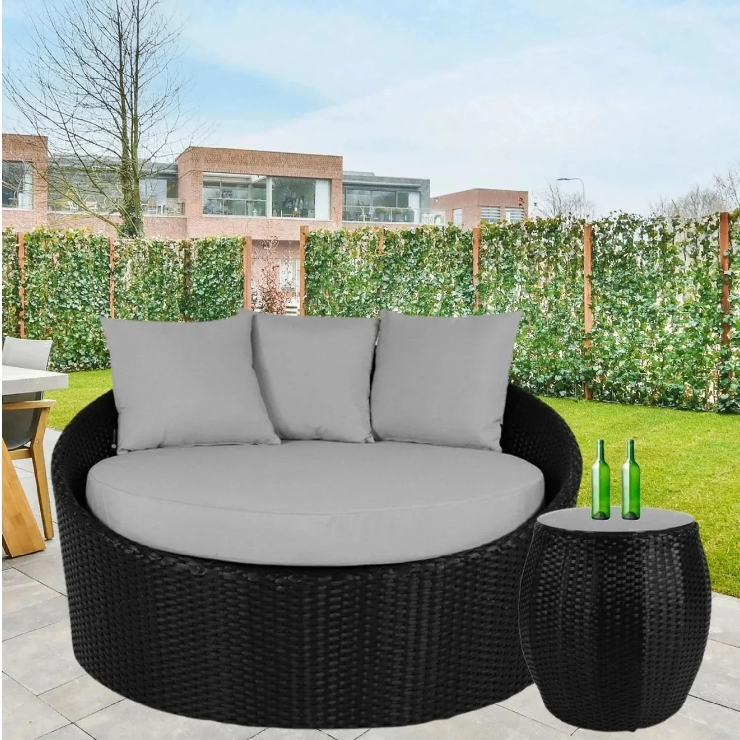 Outdoor rattan wicker daybed with plush cushions and matching glass top table for patio lounging