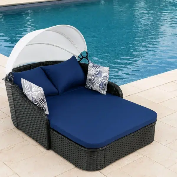 Outdoor rattan wicker double seater canopy daybed with cushions for patio and garden relaxation.