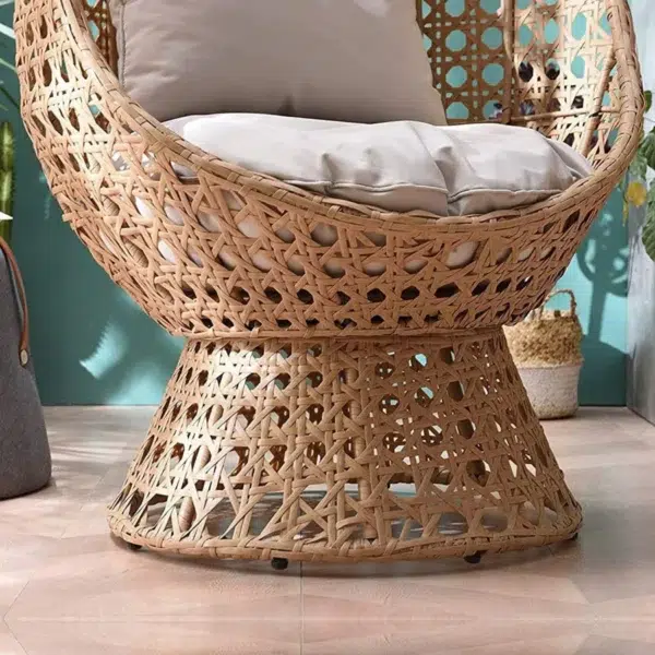 Beige rattan wicker cocoon chair with a comfortable cushion for outdoor patio or garden