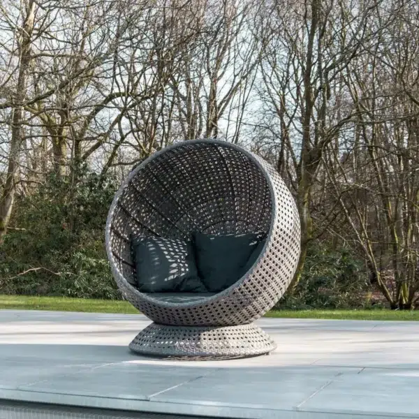 Single seater outdoor basket swing hanging on balcony with cozy cushions