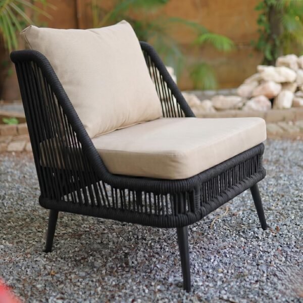 LOCCUS 4-piece outdoor rope sofa set with beige all-weather cushions and black heavy-duty metal frame, featuring a loveseat, two single chairs, and a glass-top coffee table, arranged on a patio with a brick wall backdrop and a woman seated comfortably in a garden setting.