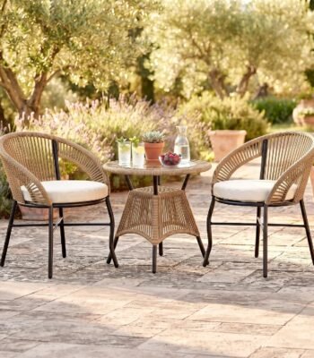Loccus 2 Seater Outdoor Patio Furniture Set with Two Rope Woven Chairs, Cream Cushions and Round Table in a Garden Setting